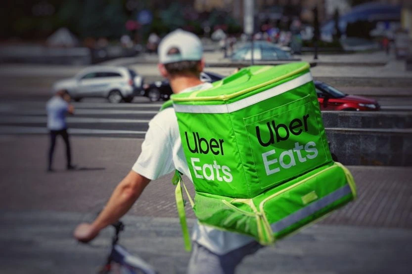 Uber Eats Delivery Rider delivering food with Uber Eats branded bag